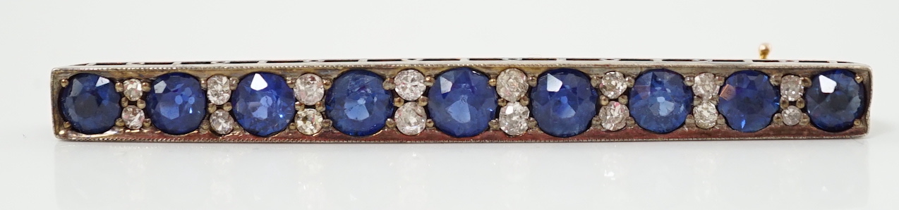 An Edwardian gold and graduated nine stone round cut sapphire set bar brooch